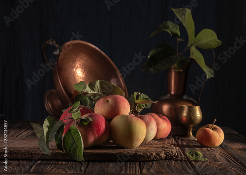 Classical still life with organic natural apples and vintage cooper decoration on old rustic wooden background.