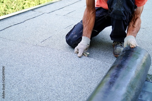 worker installing tar foil on the rooftop of building. Flat roof installation. Waterproof system by gas and fire torching. Roofing felt. Roofer working. Roofer working tool. Waterproofing