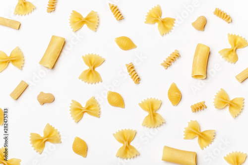 Various uncooked pasta on white background. Top view. Raw pasta with ingredients for cooking. Food concept