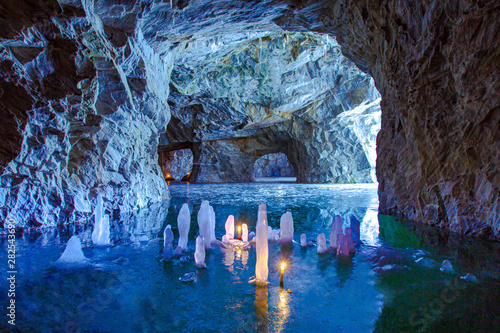 Karelia. Ruskeala. Marble cave. Ice stalactites and stalagmites. nature of Russia. In a cave burning candles. Icicles. Travelling to Karelia