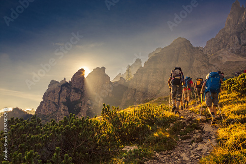 Some hikers go up a mountain path in the early hours of the day