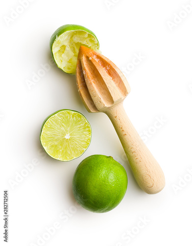 Wooden citrus squeezer and green lime.