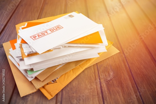 Pile of envelopes with overdue utility bills isolated on white