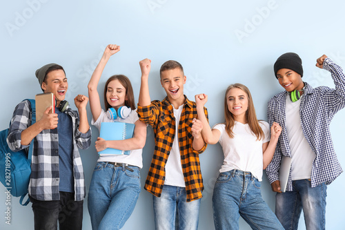 Portrait of happy young students on color background