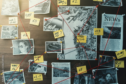 Detective board with photos of suspected criminals, crime scenes and evidence with red threads, toned
