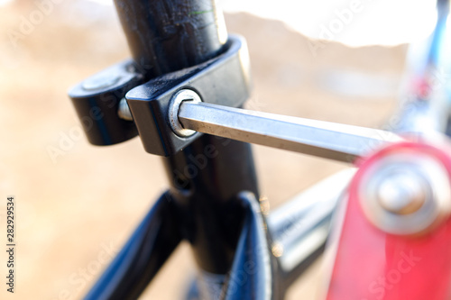 Child tightened the saddle nuts of his bicycle.