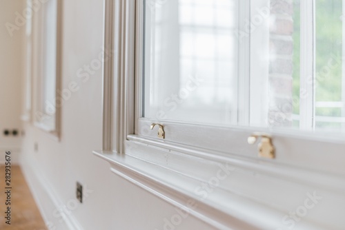 Closeup shot of a gold sash lock on a white window