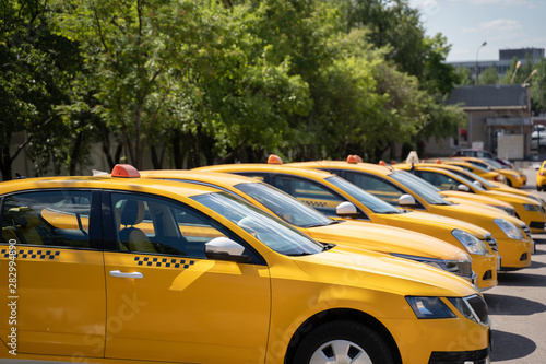 Photo of several yellow taxi on street in summer