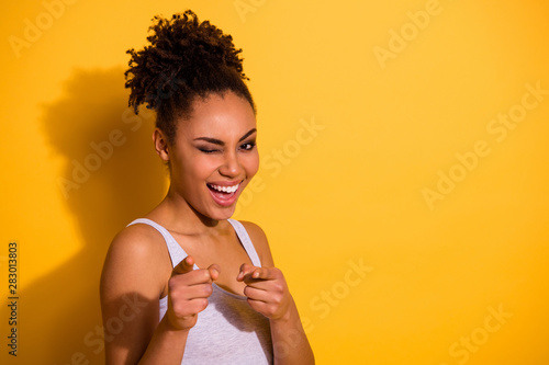 Close up photo beautiful attractive she her dark skin model lady wink one eye excited I pick select want wish you summer weekend vacation pretender wear casual tank-top isolated yellow background