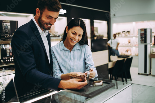 Beautiful couple enjoying in shopping at modern jewelry store.