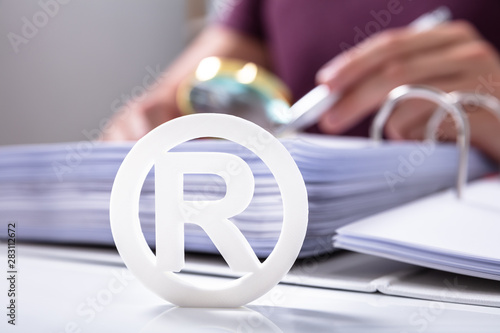 White Registered Trademark Sign Near Documents