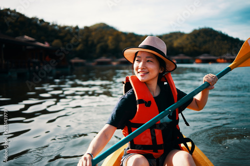 Asian girl is kayaking at Kanchanaburi, Thailand.