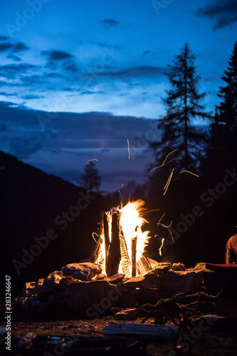 Camping bonfire with yellow and red flames in summer, forest. Copy space.