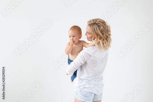 Childhood, motherhood and family concept - Portrait happy mother holds her baby on white background with copy space