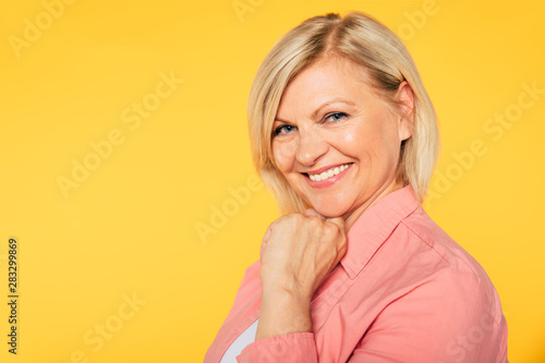 Close up portrait of happy smiling and beautiful blonde senior woman isolated in studio and posing with smile on camera