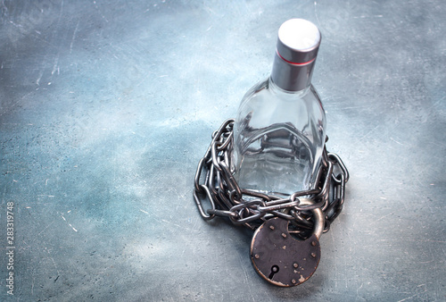 Alcoholism, alcohol addiction concept with alcohol drink bottle and chain with lock. Stop drink background. Copy space.