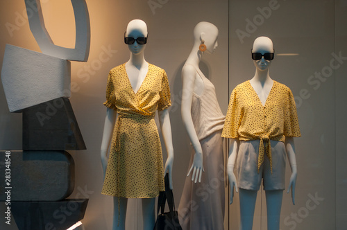 closeup of yellow summer clothes on mannequin in women fashion store showroom