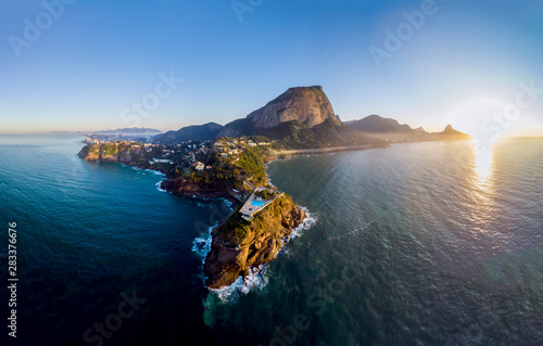 Panoramic view of the coastline and beach of Joatinga in Rio de Janeiro with its beautiful picturesque natural richness and far in the background the well known landmark peaks of the city