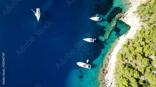 Aerial drone photo of luxury sail boats and yachts docked in turquoise clear water rocky seascape in traditional village of Assos, Cefalonia, Ionian islands, Greece