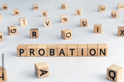 probation - word from wooden blocks with letters, time criminal is allowed to stay out of prison or period a new employee is suitable for work concept, random letters around, white background