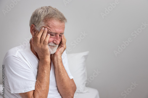 Senior elderly man sitting on bed with depressed after waking up in morning