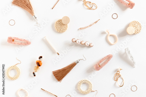 Pattern made of earrings, rings, hairpins on white background