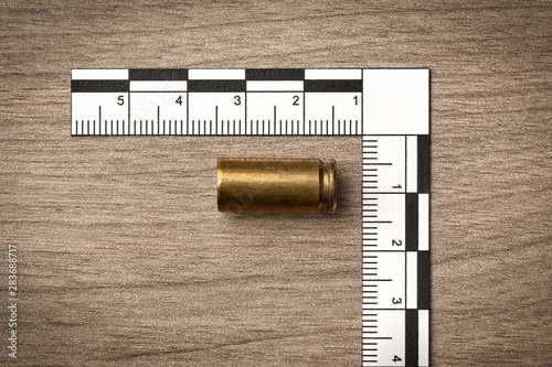 Crime Scene Investigation - bullet casing as a piece of evidence placed with forensic ruler for documentation