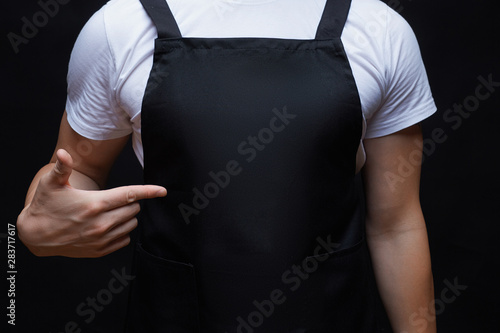 Closeup strong man wearing black apron.