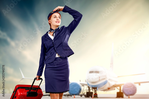 Young stewardess and airplane 