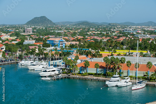 A view overlooking the marina community buildings and mountains of the Island of Aruba in the Caribbean - Image