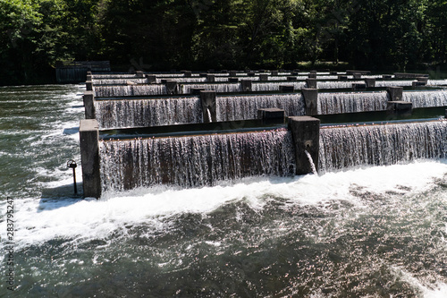 Weir dam in Tennessee on a summer day with many water falls and flowing white water