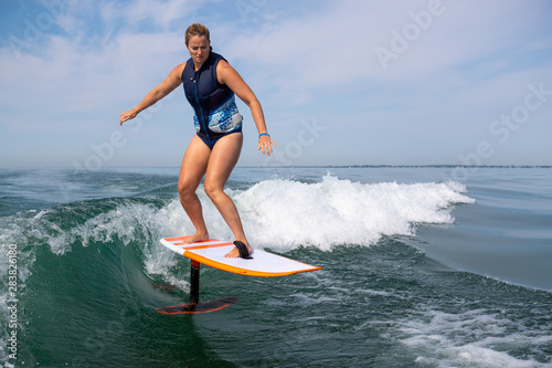 Woman wake surfing with a foil board.