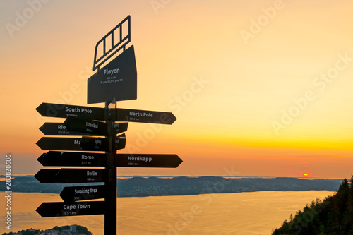 Beautiful landscape with signpost and sunset seen from the top of Mount Floyen in Bergen, Norway on July 26 2019