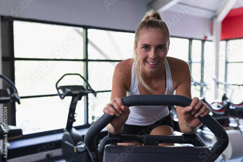 Fit woman working out on exercise bike in fitness center 