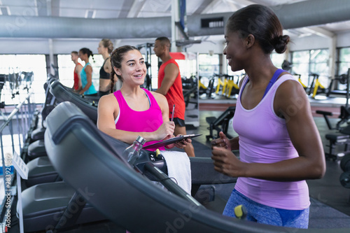 Female trainer interacting with woman in fitness center