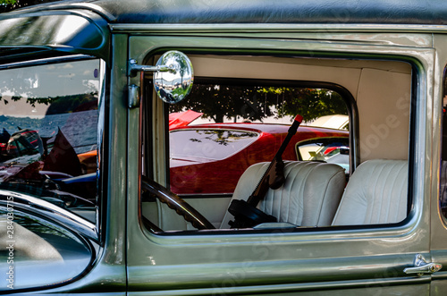 Interior view of an antique car with 'Tommy Gun' in the front seat