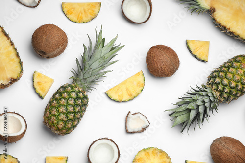 Composition with pineapple and coconut on white background, top view