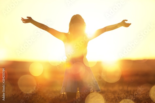 Young woman on field under sunset light