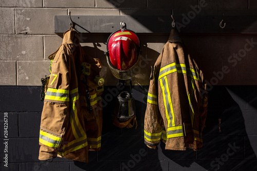 Firefighter protection gear hanging on fire station wall