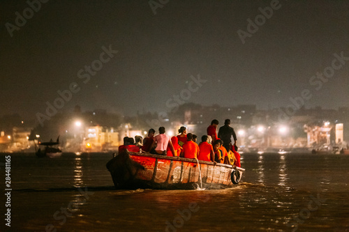 Diversity of people in the boat floating on the river are going to pray at Varanasi Ganga Aarti at holy Dasaswamedh Ghat, near Kashi Vishwanath Temple, Varanasi, India.