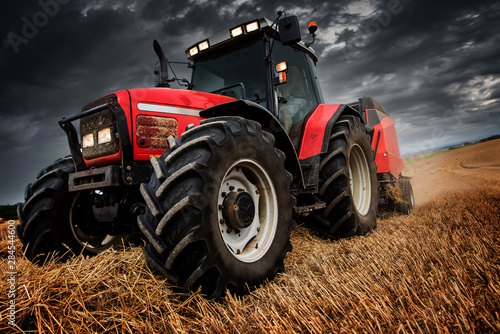 farmer in fields making straw bales