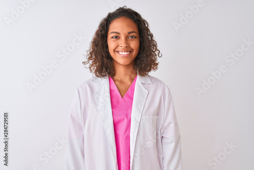 Young brazilian doctor woman wearing coat standing over isolated white background with a happy and cool smile on face. Lucky person.