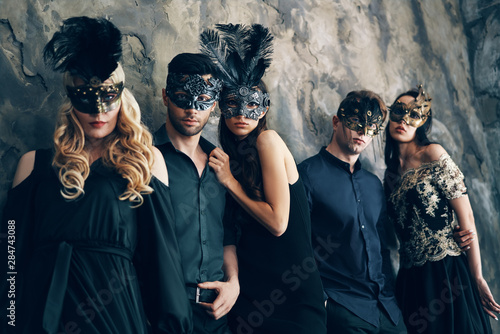 Group of people in masquerade carnival mask posing in studio