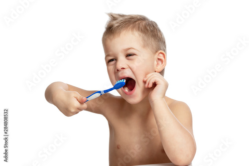 The little boy is actively brushing his teeth. Close-up. Isolated over white background.
