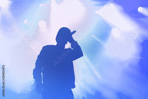 Silhouette of rap singer performing on concert. Rapper singing on stage in night club. Hip hop images for poster design