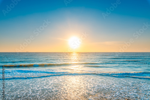 The ocean under the blue sky and the sunset in the evening