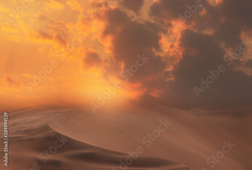 Beautiful gold sand dunes and dramatic sky with bright clouds in the Namib desert