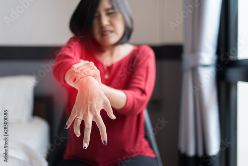 Woman suffering with parkinson's disease symptoms,Selective focus hands