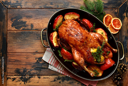 Roast goose stuffed with baked apples in a skillet, festive christmas recipe. Top view with copy space.