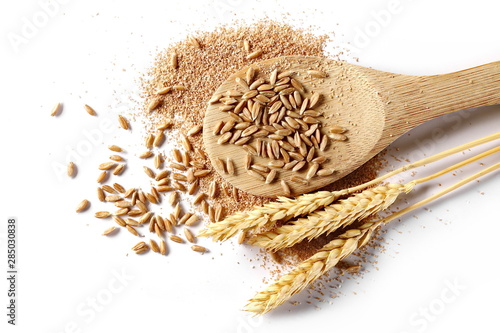 Spelt bran and grains with wooden spoon and ears of wheat isolated on white background, top view
